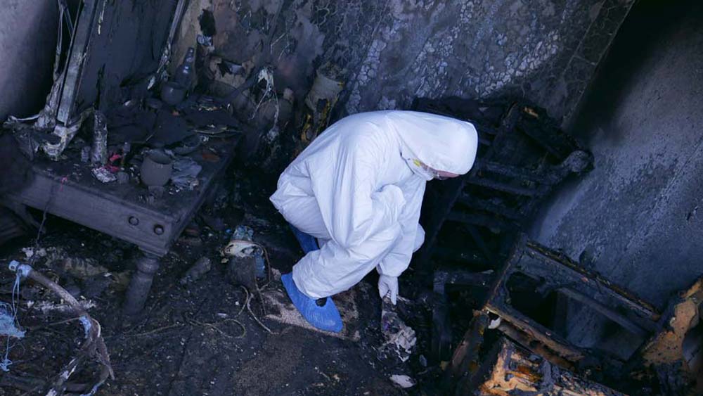 Student practices evidence gathering techniques at a simulated fire scene