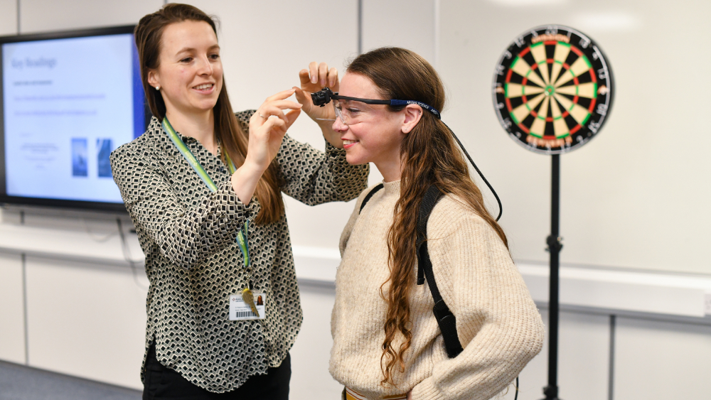 A Marjon psychology student has a pair of glasses with a camera attached adjusted by a lecturer