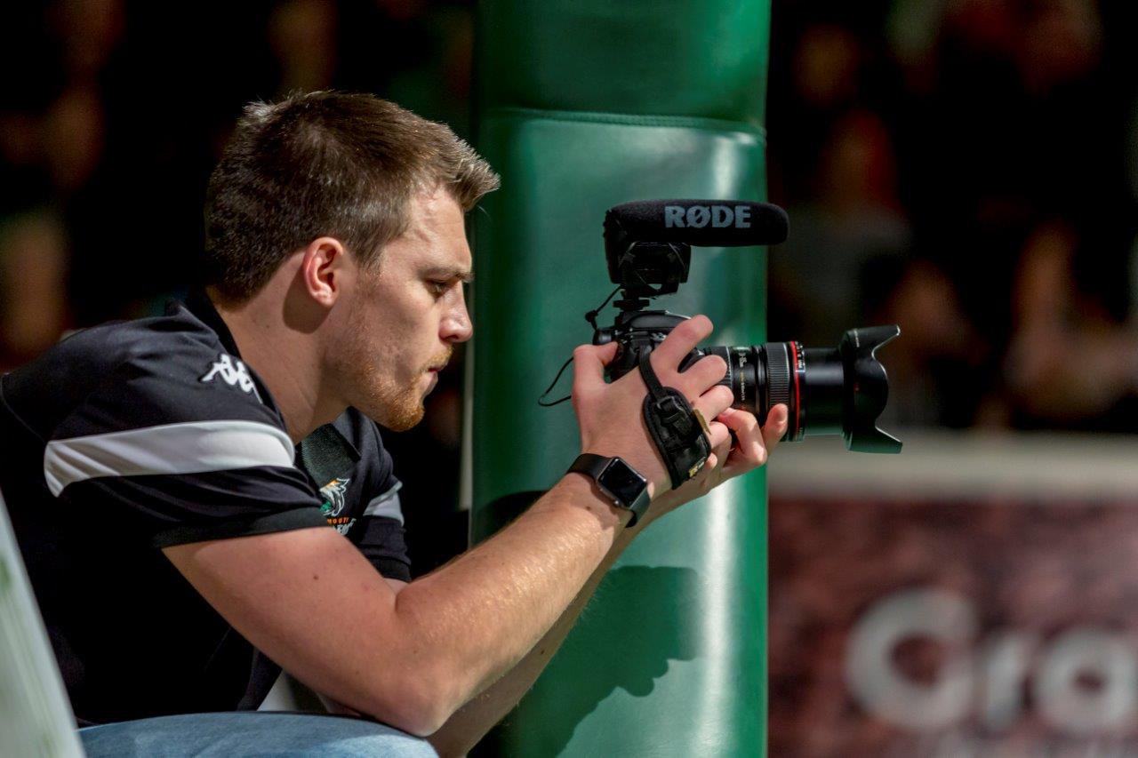 Jack taking a photo at a basketball game