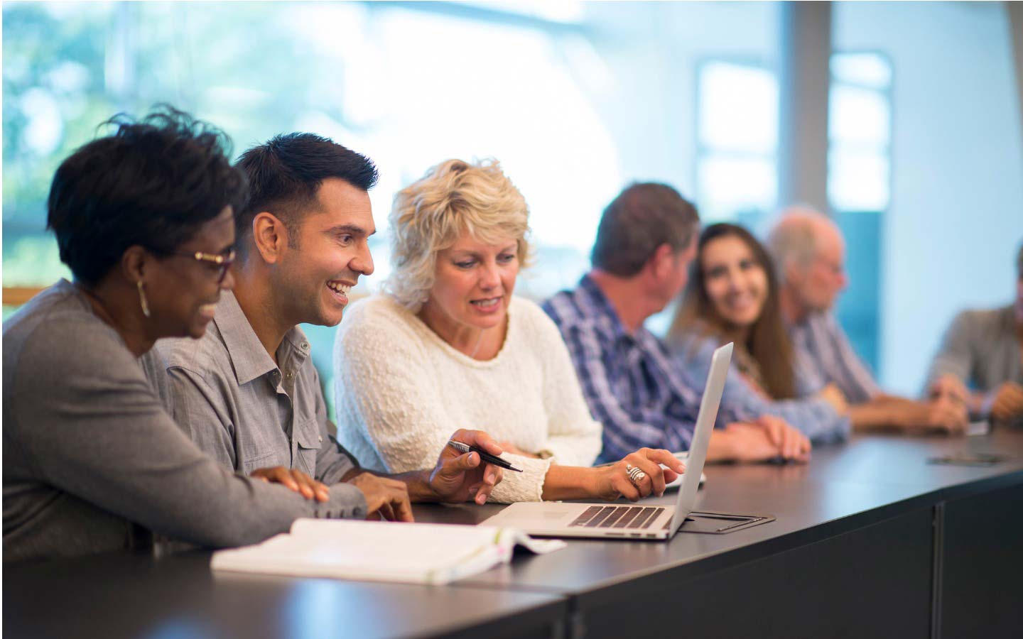 Six postgraduate students at a long study desk