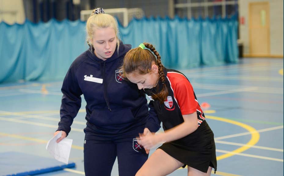 Student encourages pupil during running exercise