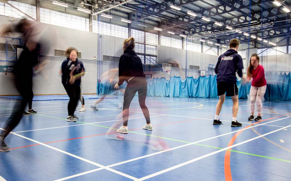 Students practice a PE exercise in the sports hall