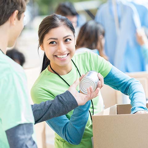 Female smiling handing over a can