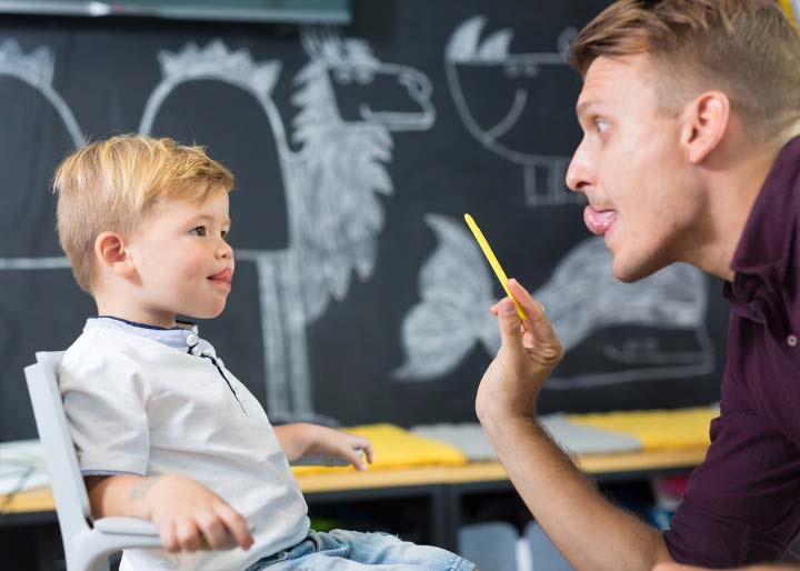 Male speech therapist works with child
