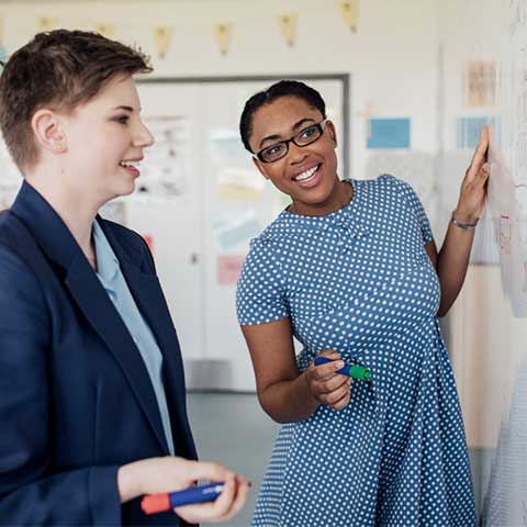 A student offering one-on-one teaching to a secondary school pupil.