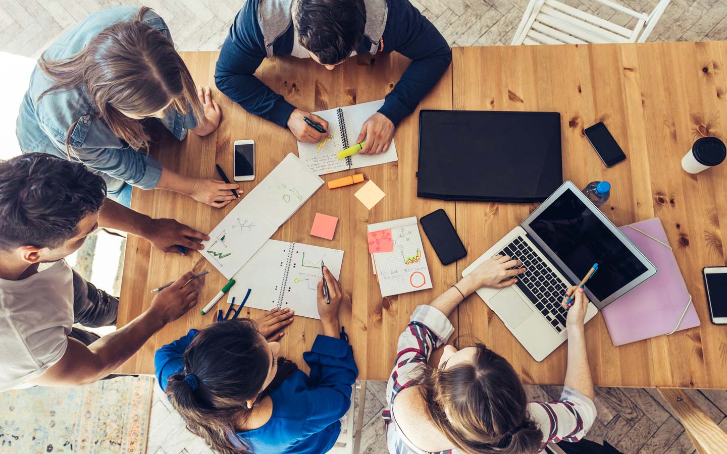 A table packed with notes and electronic devices