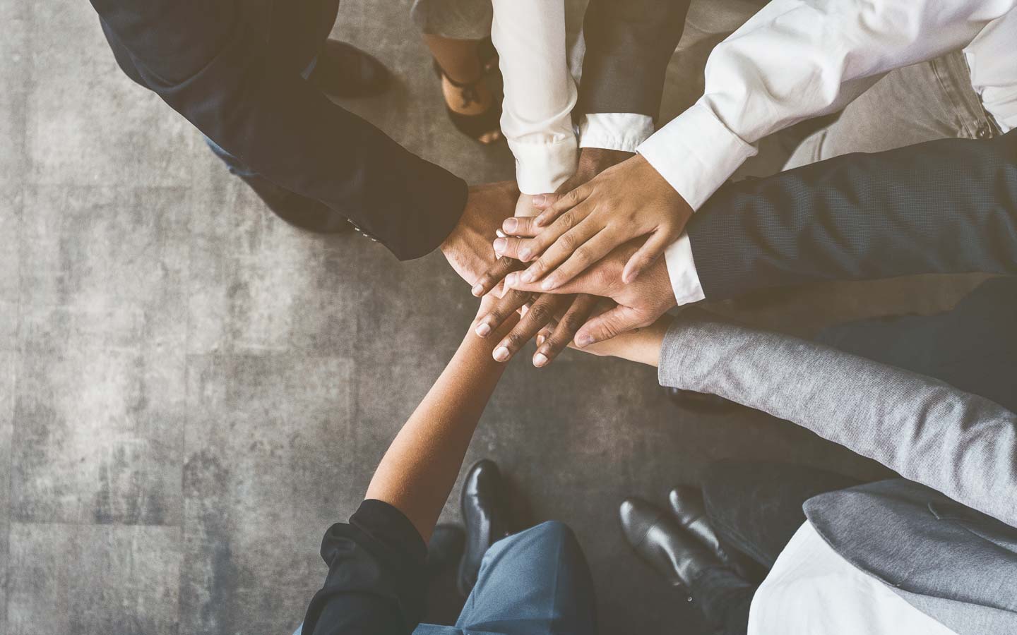 People have stacked their hands one on top of one another to symbolise team work and trust