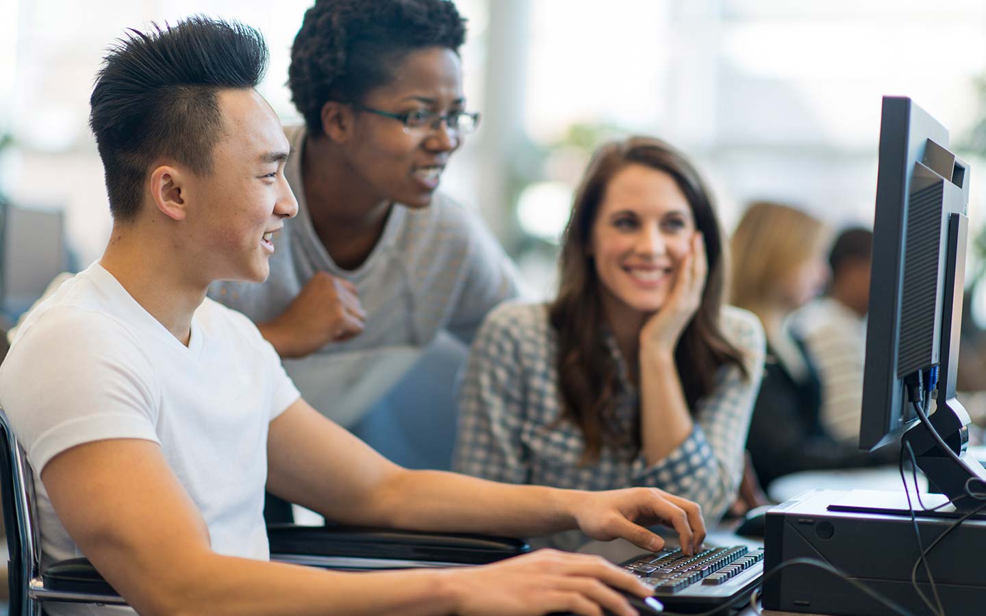 Three students gathered around a computer