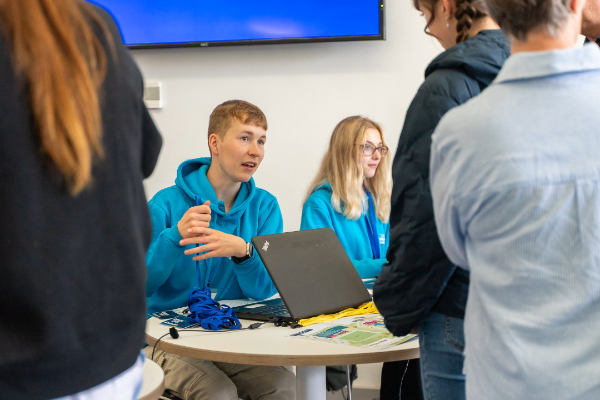Male student ambassador registering people at the Open Day