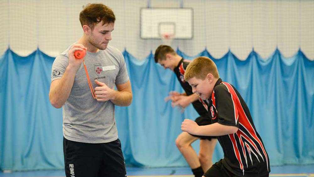 A trainee Marjon PE teacher encourages his pupil who is running