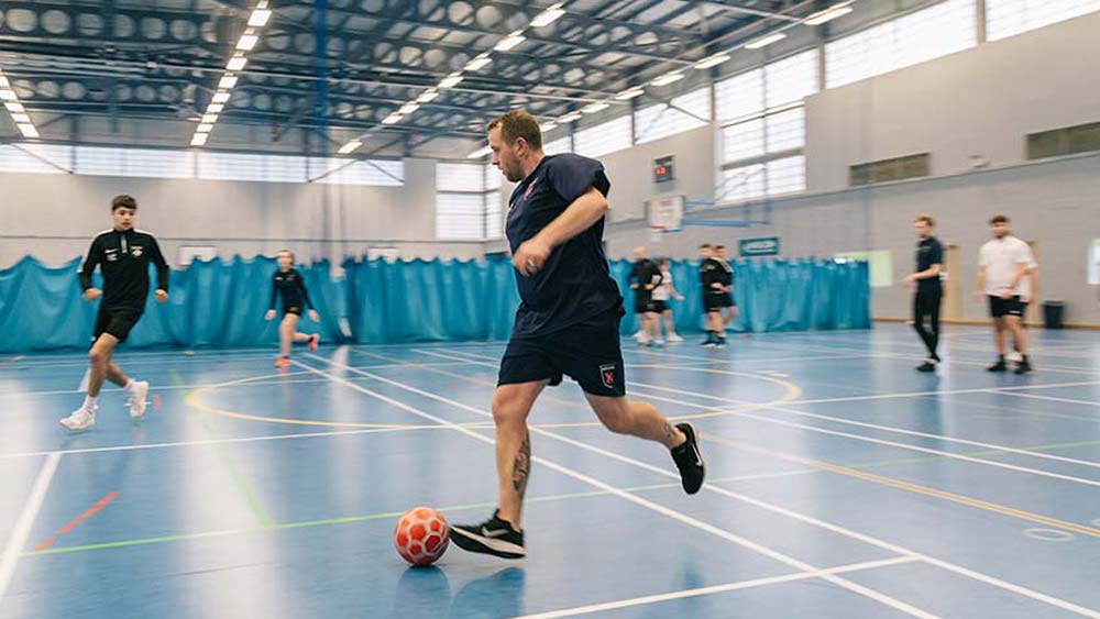 Students playing football during a practical coaching session