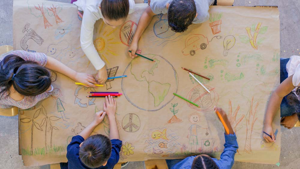 postgraduate courses in youth and community work Children drawing together on a massive sheet of brown wrapping paper