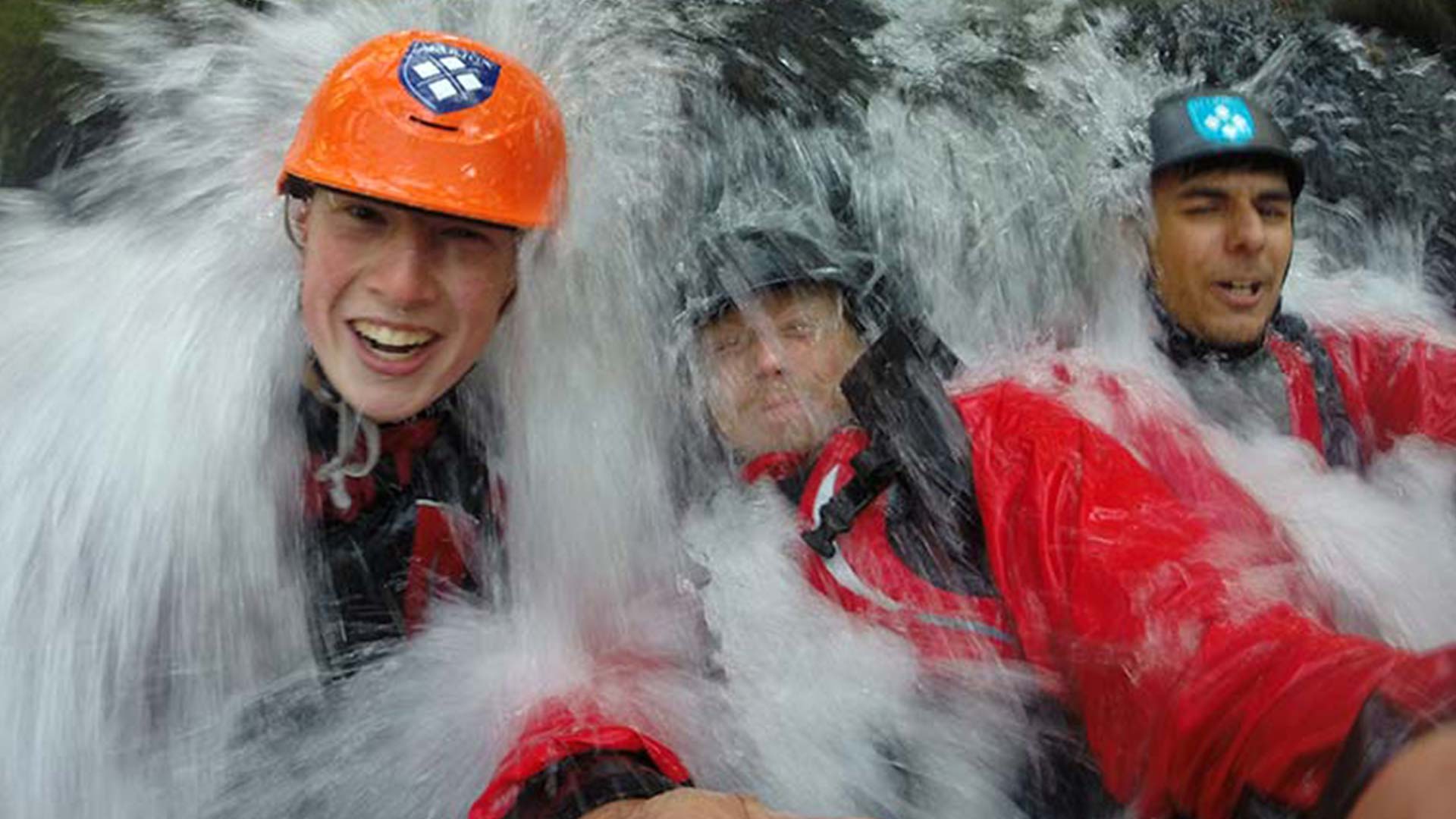 Outdoor education students under waterfall