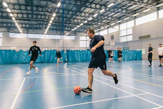 Students playing football during a practical coaching session