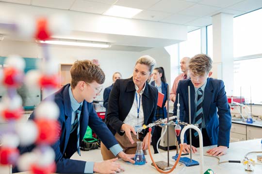 A science teacher and pupils do an experiment in the lab