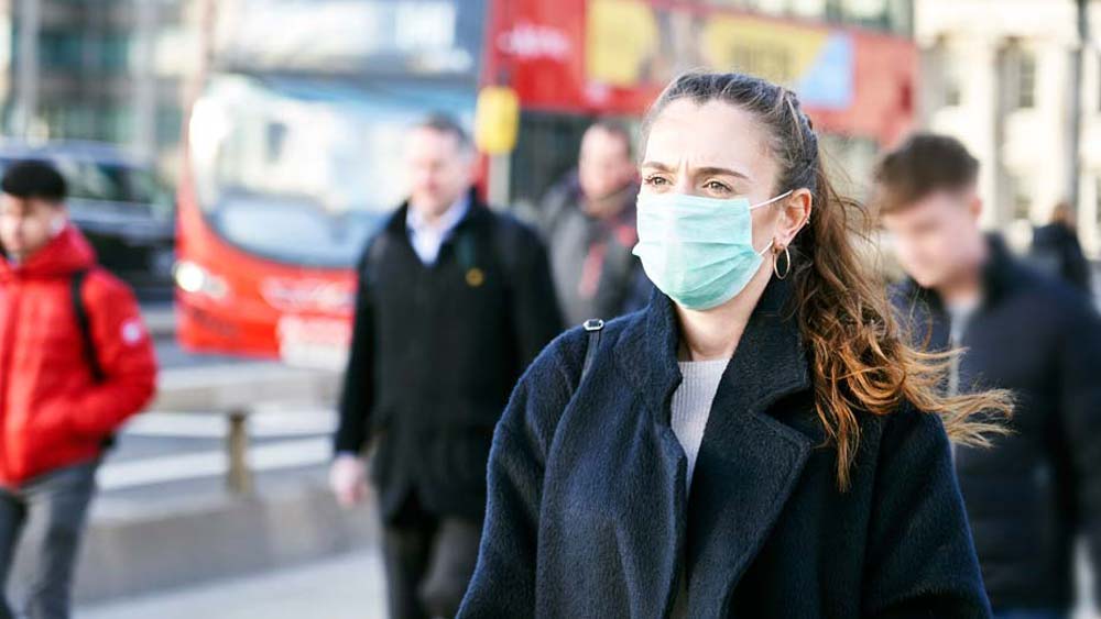 Woman walking outside while wearing a face covering