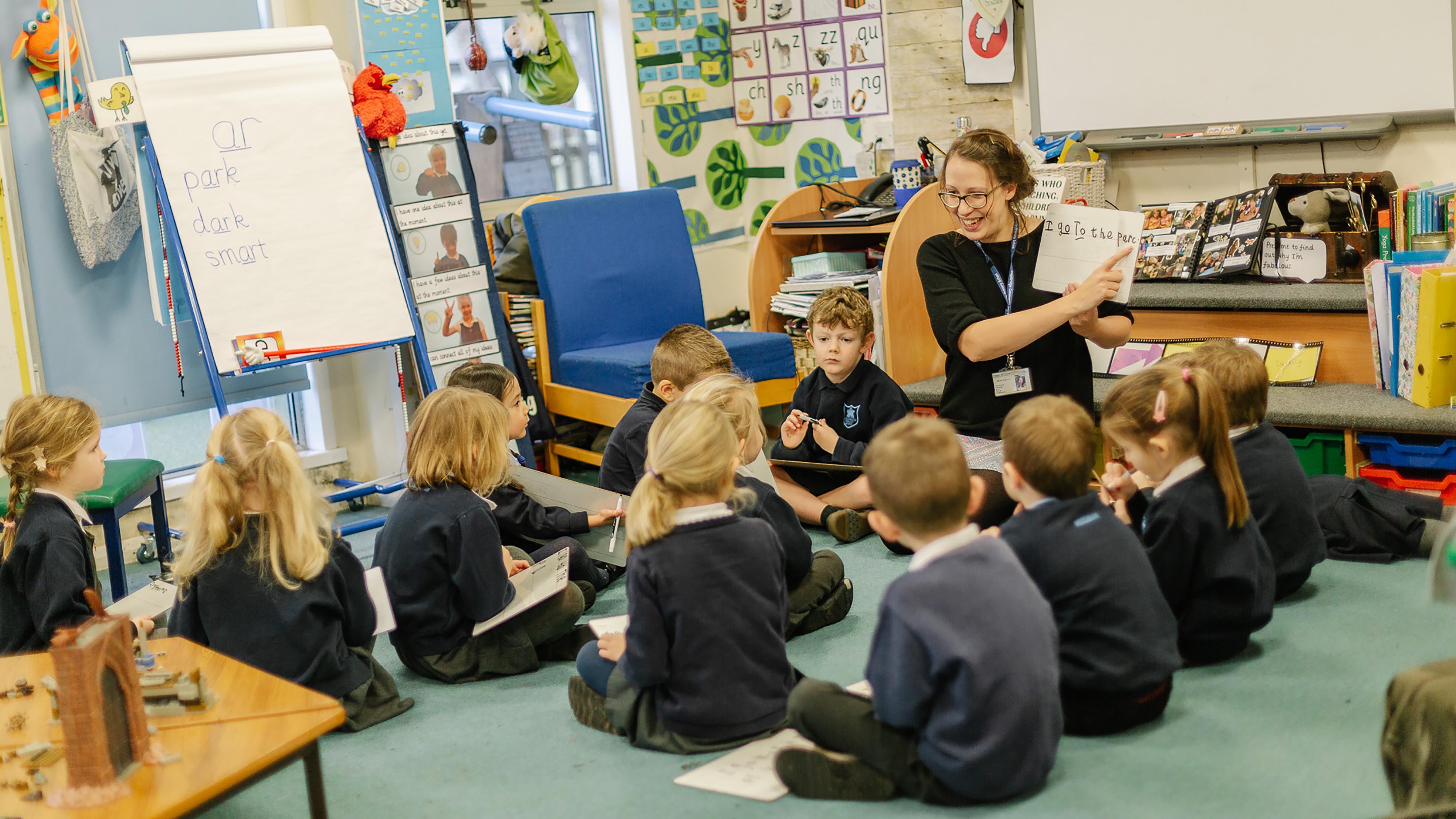 A primary school teacher reads to the class