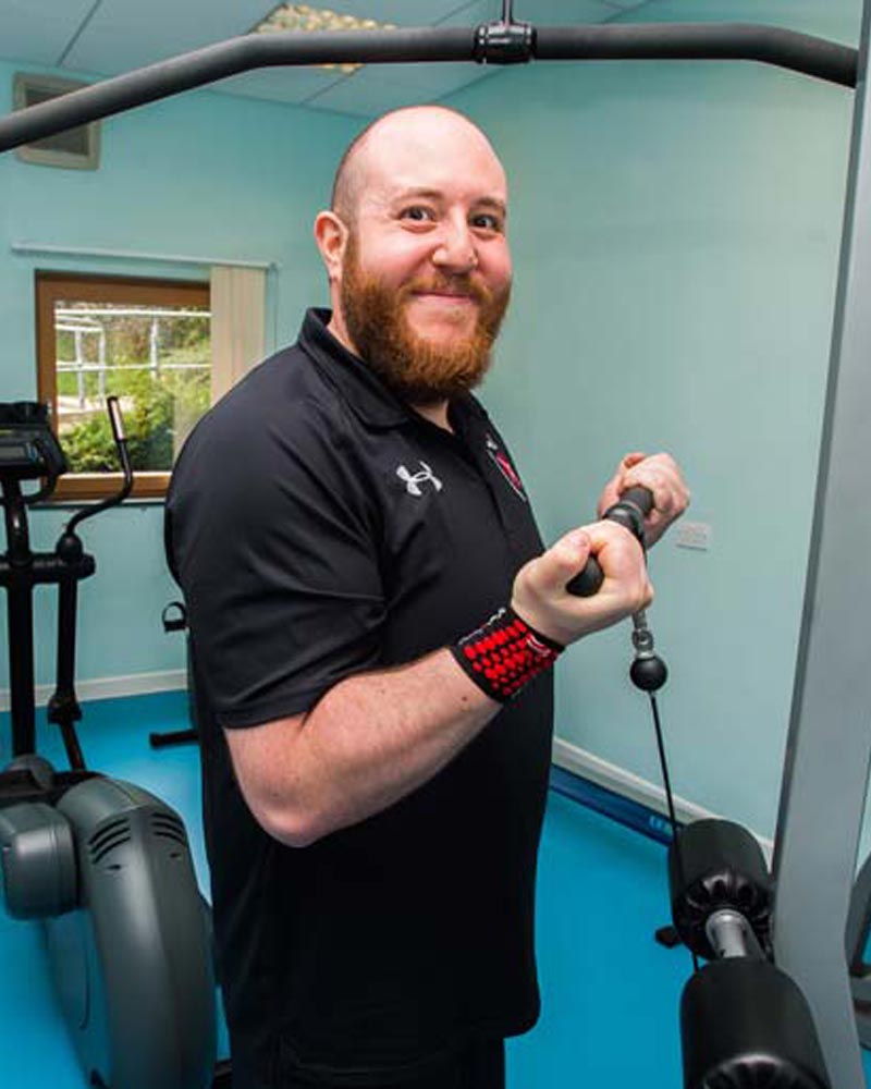 Friendly fitness trainer smiles at camera