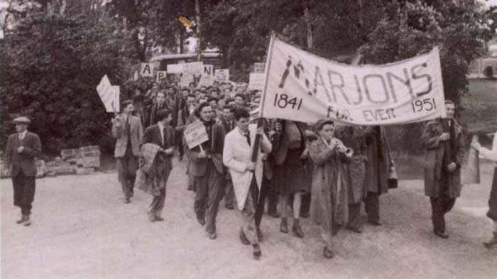 Marjon students march with a banner to celebrate our centenary 
