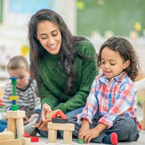 Youth worker plays with very young children