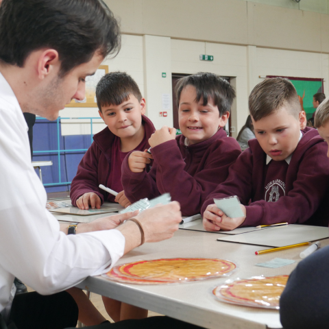 A trainee teacher working with a group of children.