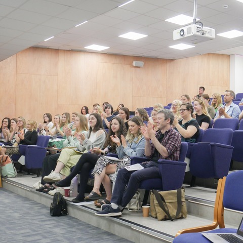 Students applauding in a lecture theatre