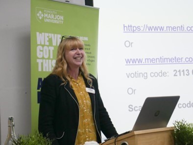 Professor Ovenden-Hope speaks in front of a screen