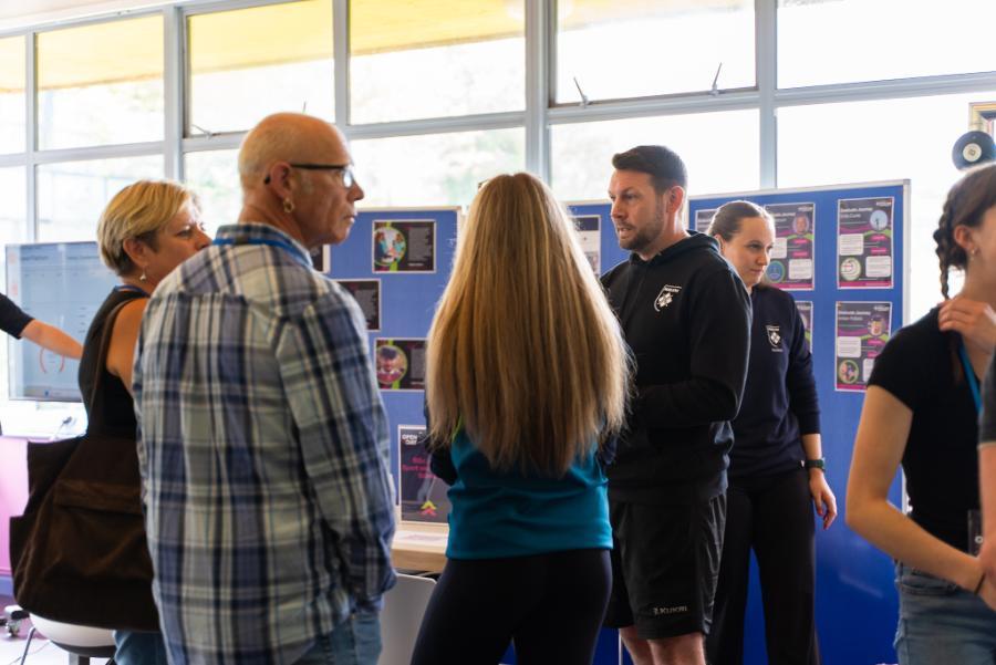 Male lecturer speaking to prospective student and family at Open Day