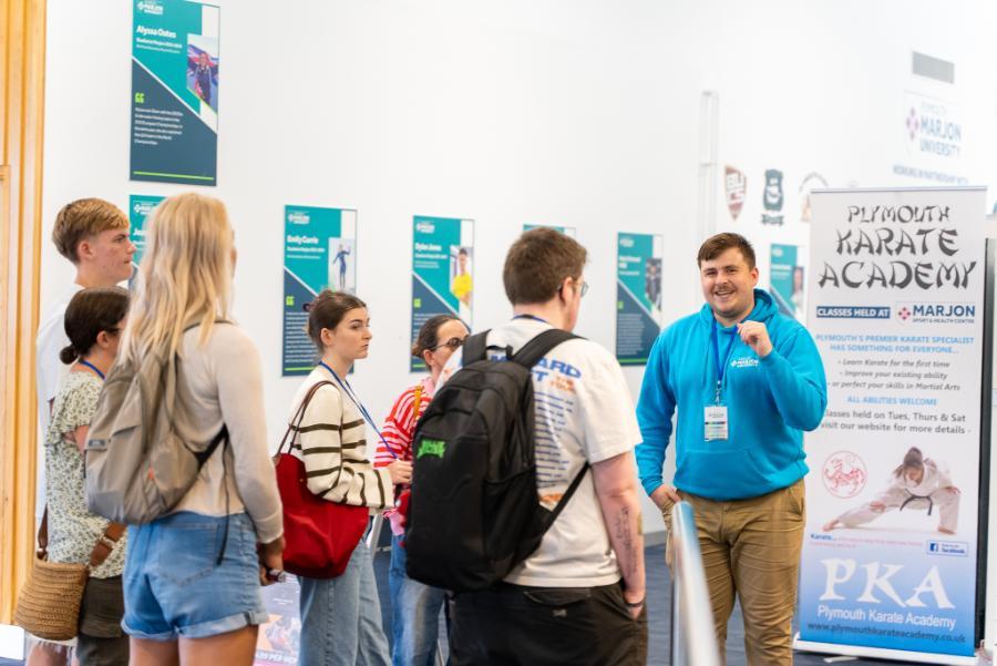 Male student ambassador completing a tour, smiling at the camera