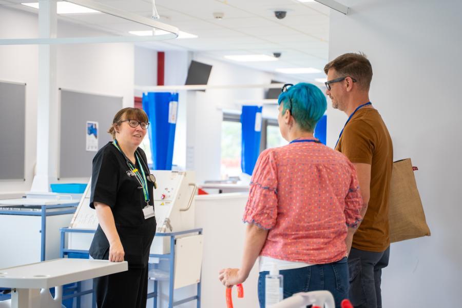 female member of staff speaking to two people on Open Day