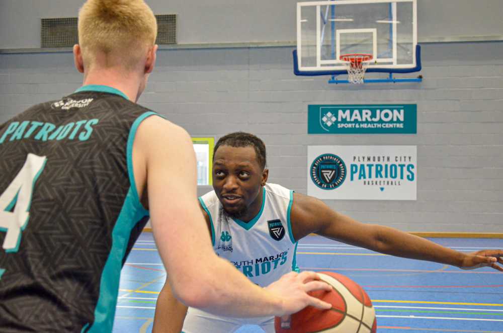 Two men playing basketball dressed in the Plymouth Patriots strip