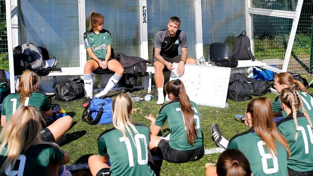 Women footballers listen to their coach