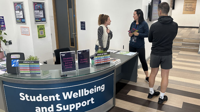 Student Wellbeing and Support staff member chatting to prospective students