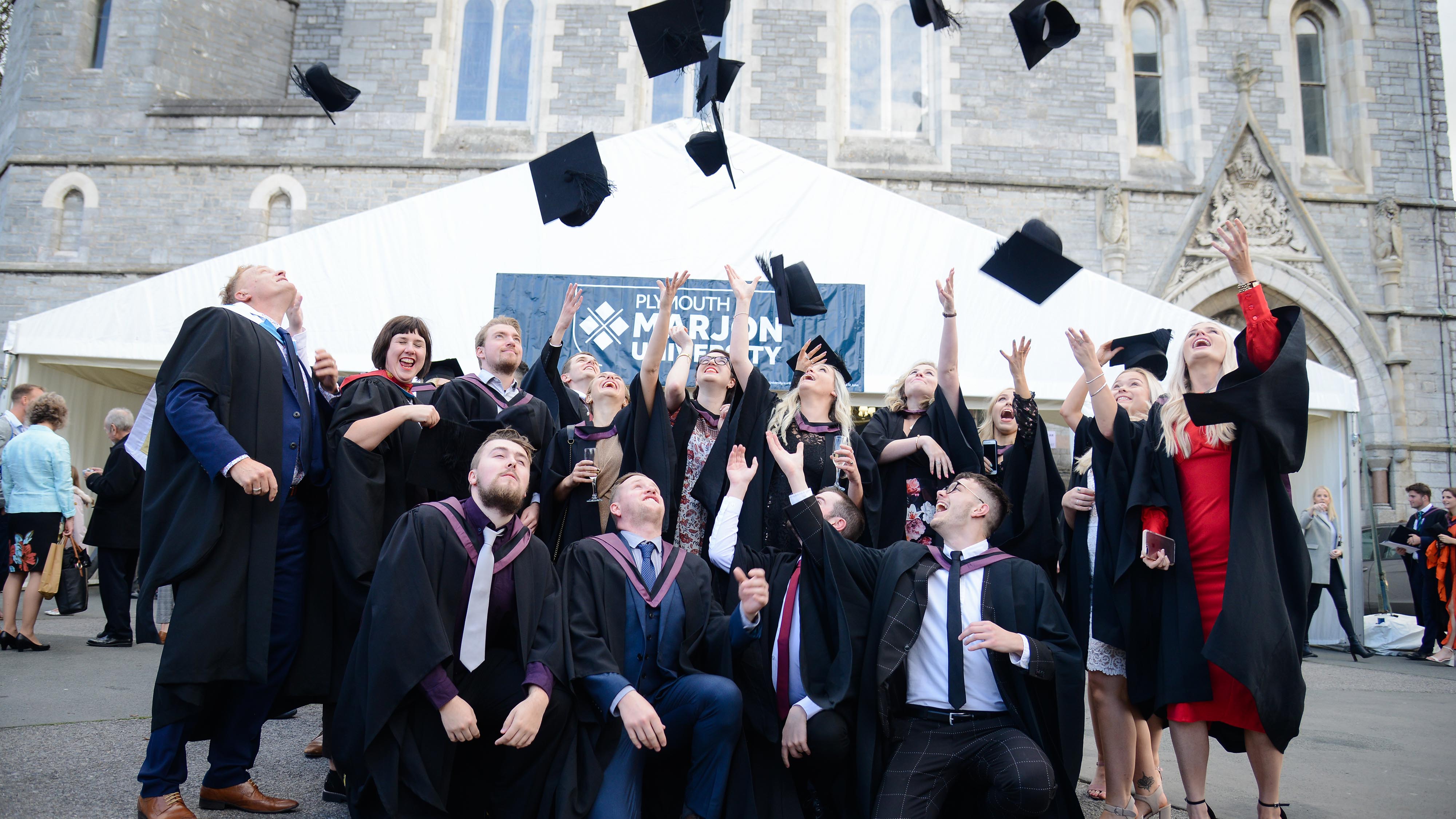 Graduates throw their caps