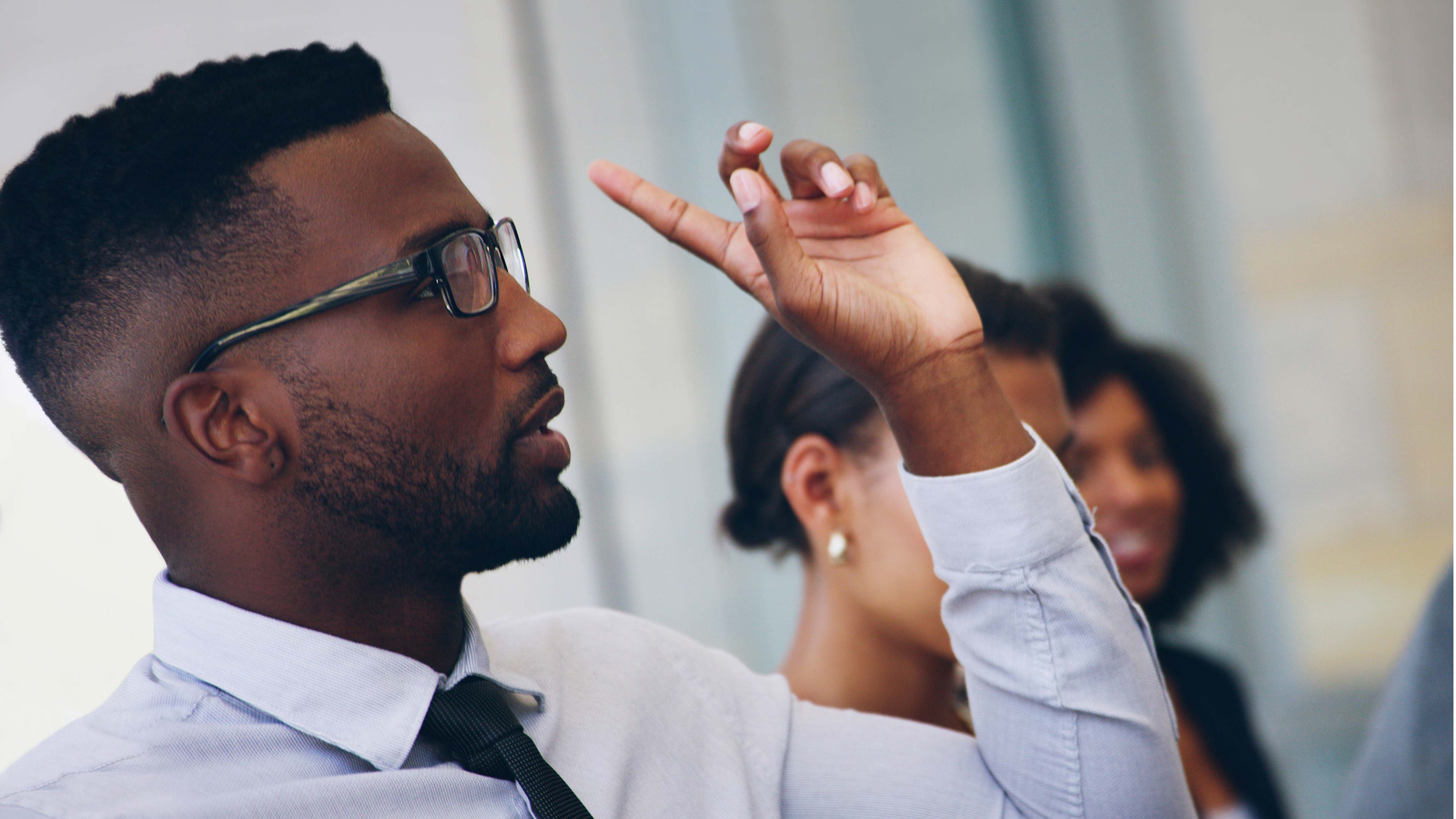 A student who is dressed smartly raises his hand