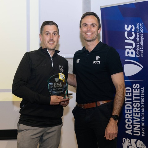 Man receives glass award from another man
