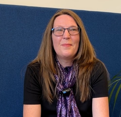 Smiling woman with brown hair and glasses