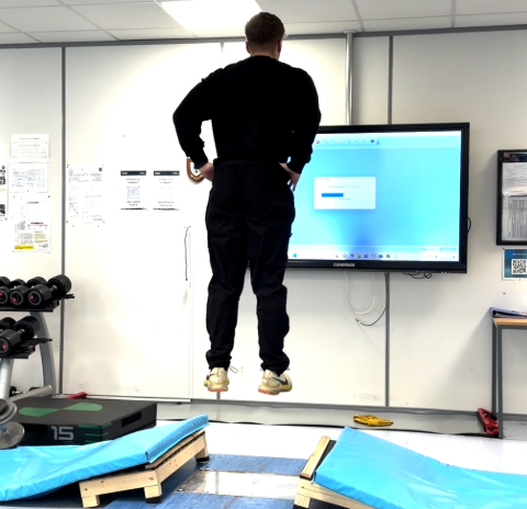 Student jumping off force plates in the lab