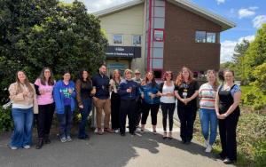 Group of smiling students outside health and wellbeing hub building