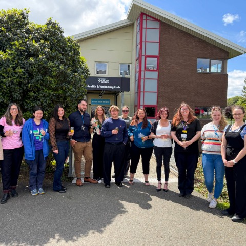 Group of smiling students outside health and wellbeing hub building