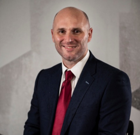 A man wearing a white shirt, red tie and black jacket