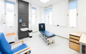 A gym in a clinic room with weights and exercise bike