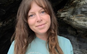Smiling woman with brown hair and turquoise t-shirt