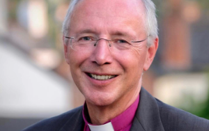 Smiling University Chancellor with glasses and dog collar