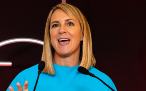 Smiling woman at lectern with microphones