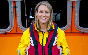 Smiling woman in yellow RNLI waterproofs and lifejacket