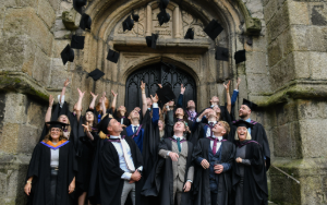 Group of graduating students throw hats in the air