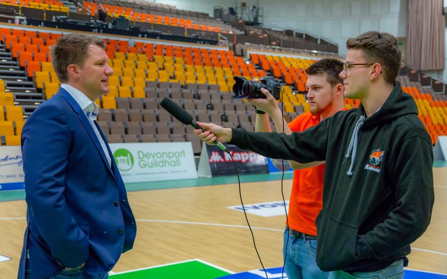 Students interviewing male at Raiders