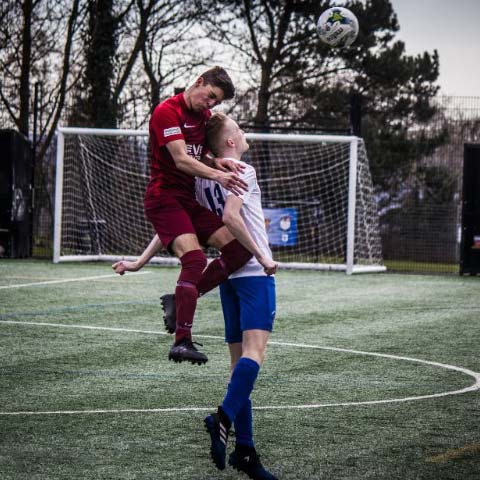 Two males playing football